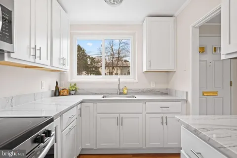 a kitchen with granite countertop a sink stainless steel appliances and cabinets