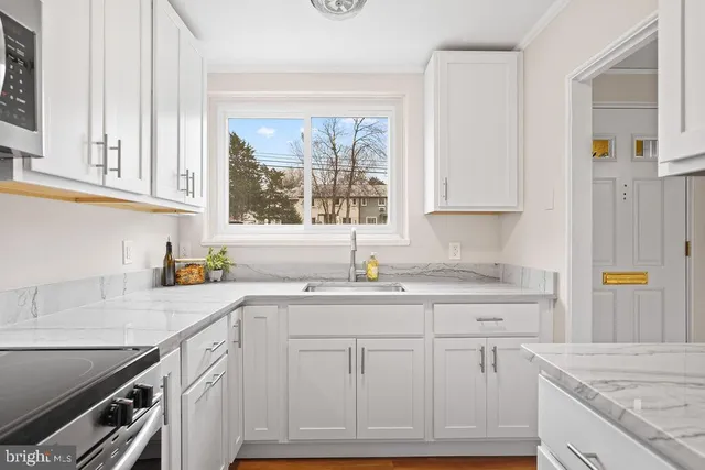 a kitchen with granite countertop a sink stainless steel appliances and cabinets