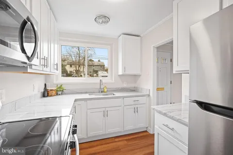 a kitchen with a sink a stove a refrigerator and cabinets