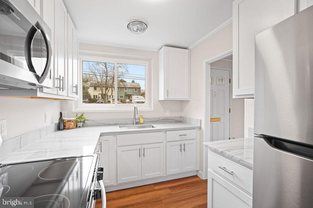 13 Ridge Road Greenbelt, MD 20770 - Photo 7 of 32 a kitchen with a sink a stove a refrigerator and cabinets