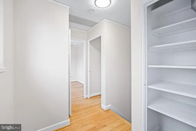 a view of a bedroom with wooden floor and closet