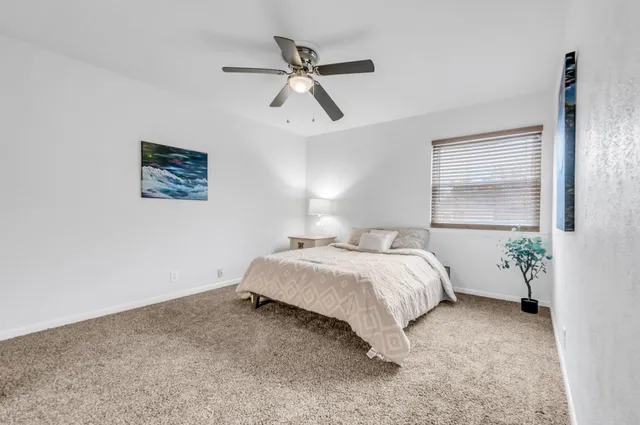 a bed room with a bed and a painting on the wall
