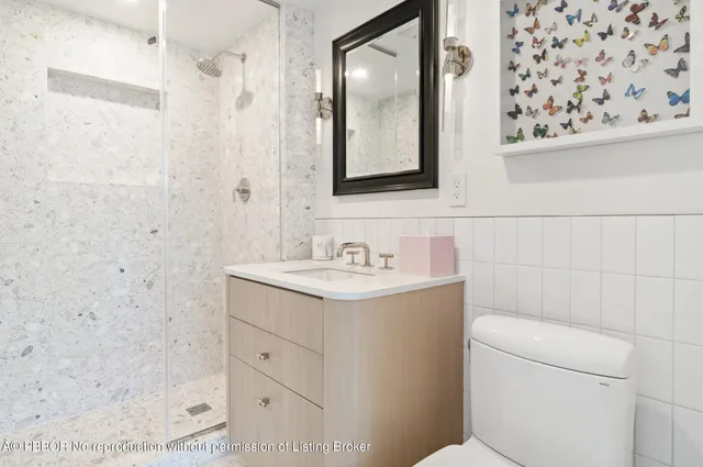 a bathroom with a granite countertop sink toilet and shower
