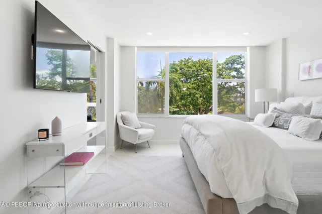 a bedroom with a bed and large windows