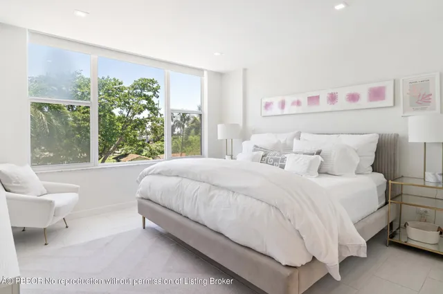 a bedroom with a bed and a large window