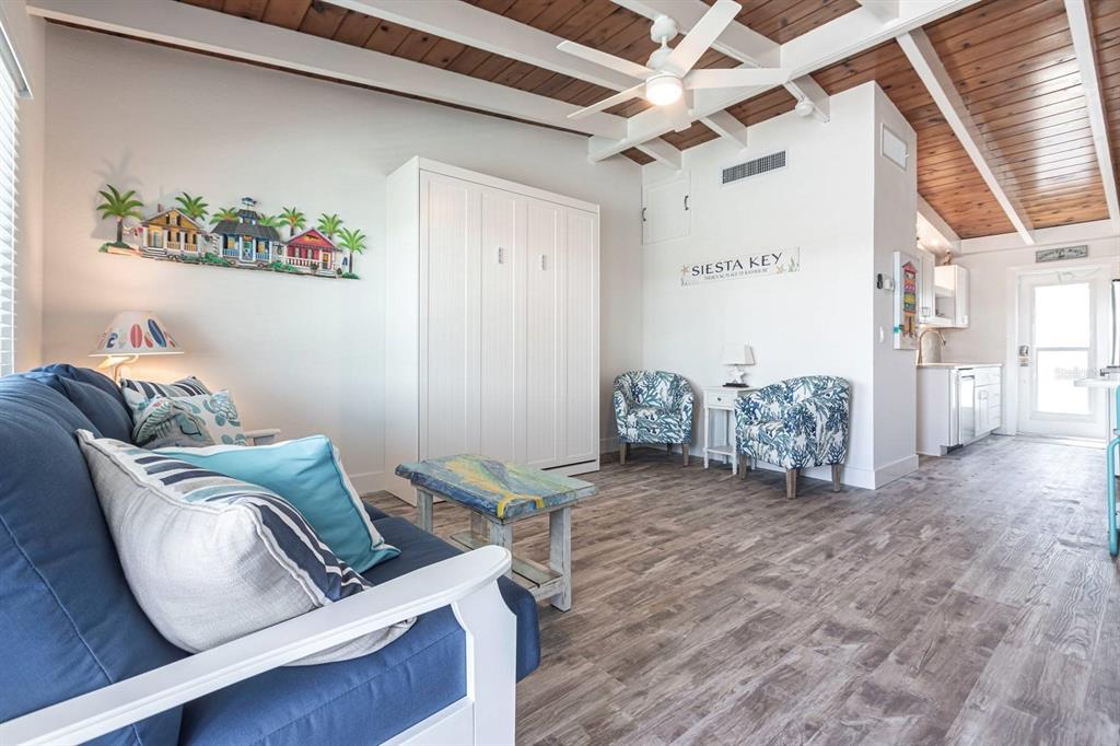 6006 Midnight Pass Road, Unit 29 Sarasota, FL 34242 - Photo 2 of 19 a living room with furniture and a wooden floor