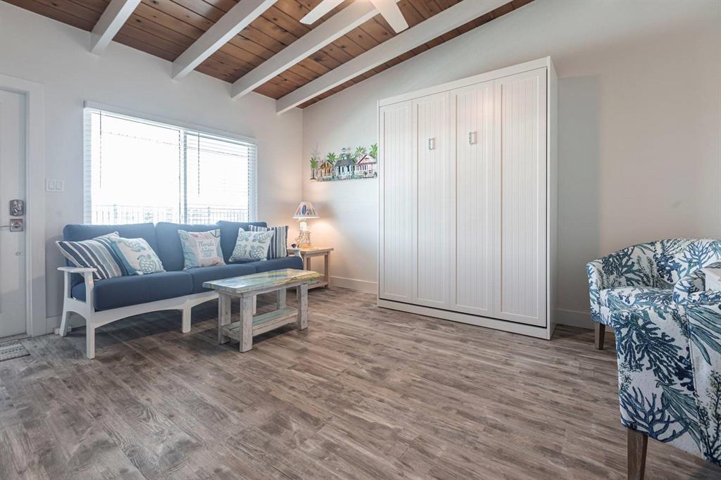 6006 Midnight Pass Road, Unit 29 Sarasota, FL 34242 - Photo 3 of 19 a living room with furniture and a wooden floor