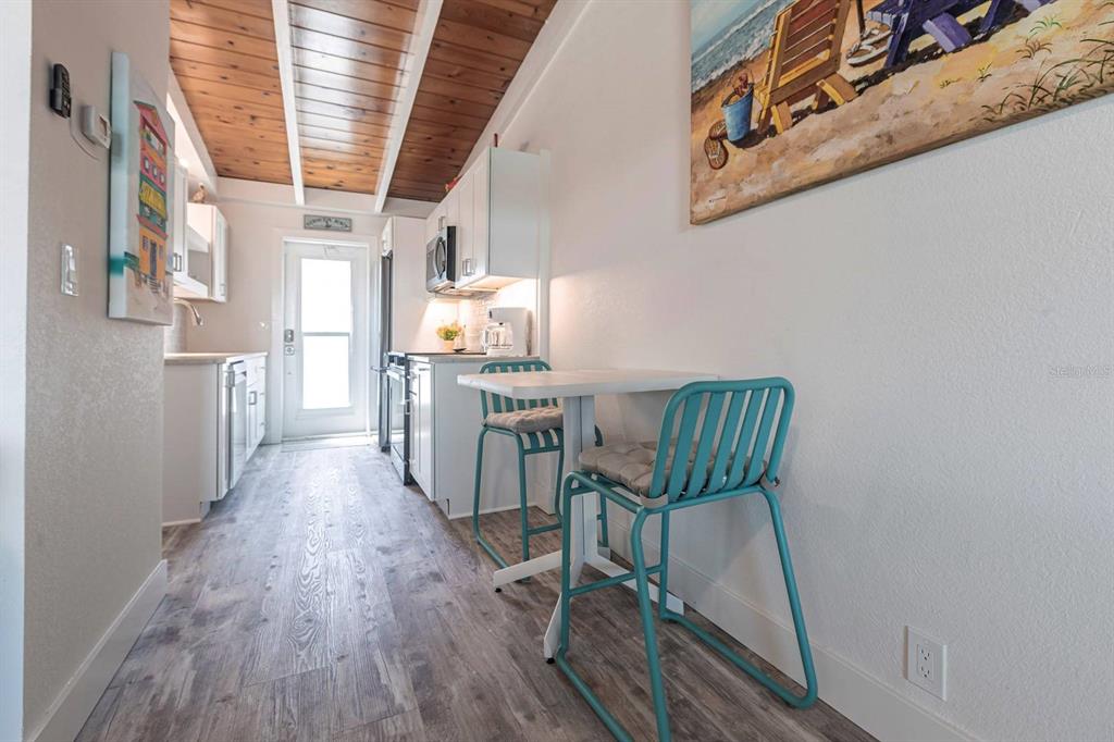 6006 Midnight Pass Road, Unit 29 Sarasota, FL 34242 - Photo 5 of 19 a view of a kitchen with furniture and wooden floor