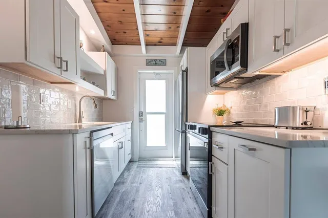 a kitchen with stainless steel appliances granite countertop a sink and cabinets