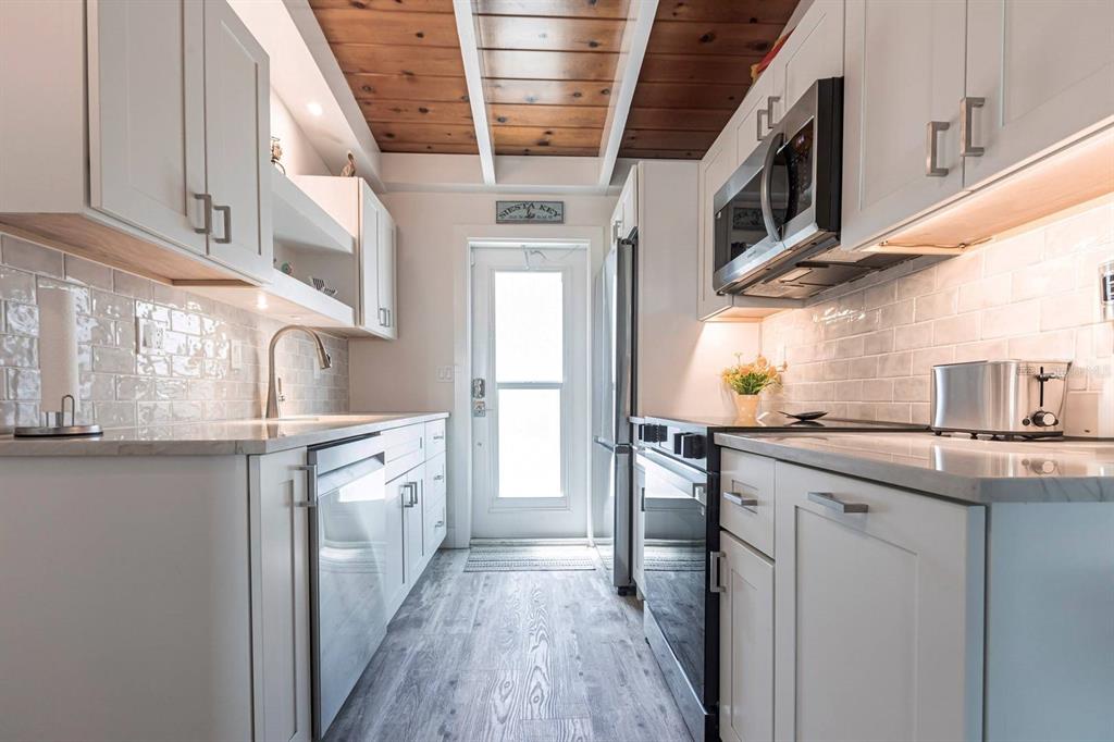 6006 Midnight Pass Road, Unit 29 Sarasota, FL 34242 - Photo 6 of 19 a kitchen with stainless steel appliances granite countertop a sink and cabinets