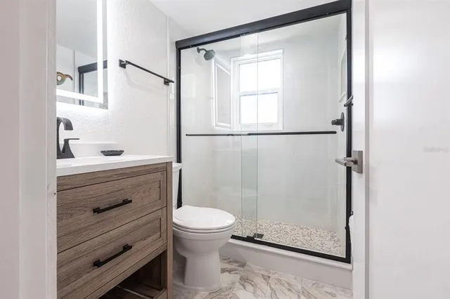 a bathroom with a shower a toilet and a sink