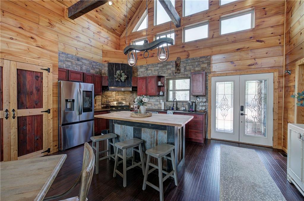 100 Buckwood Farms Path Dallas, GA 30132 - Photo 8 of 70 a kitchen with stainless steel appliances granite countertop a table chairs refrigerator and cabinets