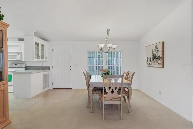 a view of a dining room with furniture a chandelier and wooden floor