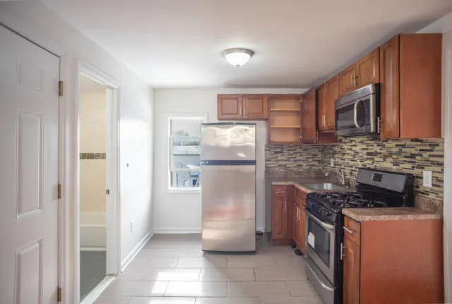 a kitchen with stainless steel appliances granite countertop a refrigerator and a stove