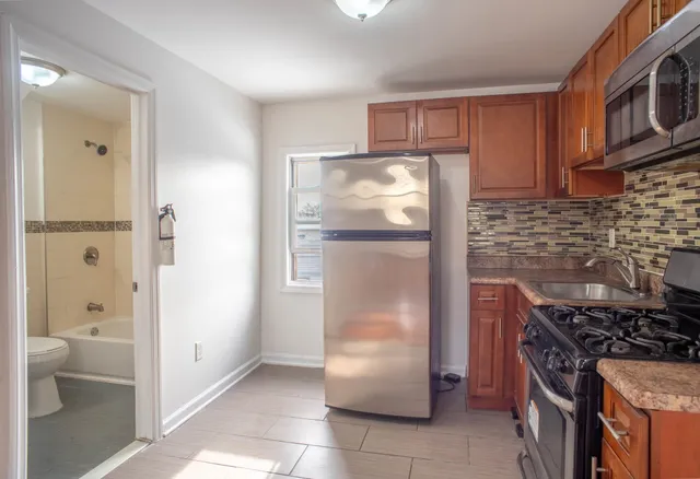 a kitchen with stainless steel appliances granite countertop a refrigerator and a stove