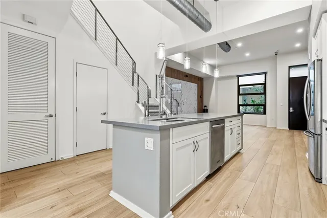 a large kitchen with stainless steel appliances granite countertop a stove a sink dishwasher and a refrigerator