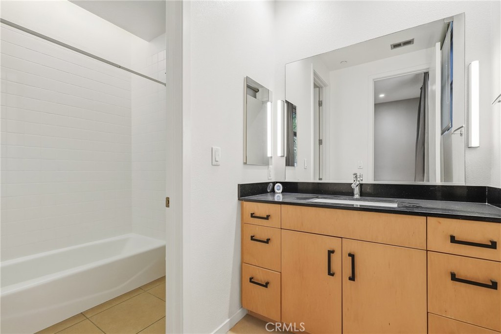 133 The Promenade North, Unit 118 Long Beach, CA 90802 - Photo 17 of 35 a bathroom with a granite countertop sink and a mirror