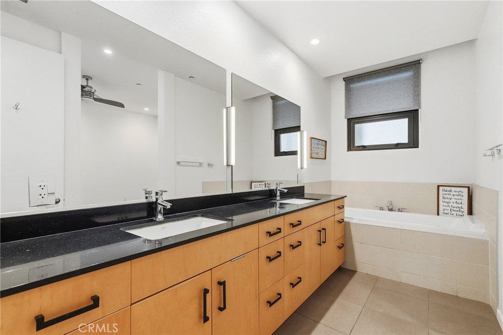 133 The Promenade North, Unit 118 Long Beach, CA 90802 - Photo 18 of 35 a bathroom with a granite countertop sink mirror and bathtub