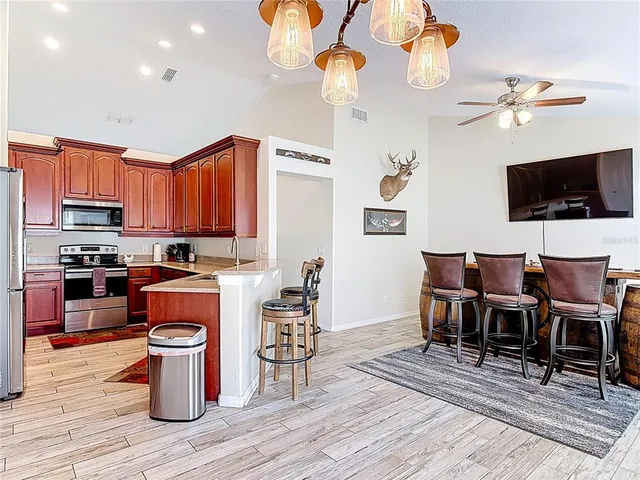 an open kitchen with wooden floor and stainless steel appliances