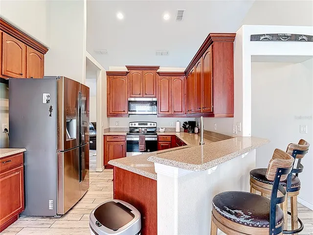 a kitchen with a refrigerator a stove top oven a sink and cabinets