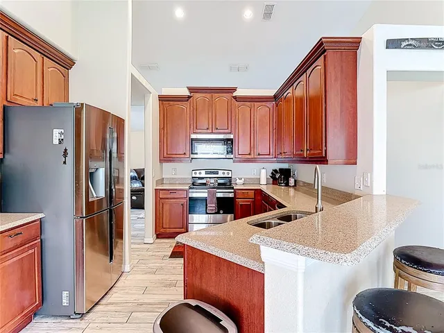 a kitchen with stainless steel appliances granite countertop a sink stove and cabinets