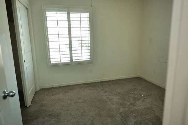 an empty room with windows and closet