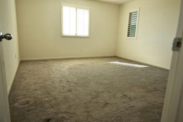 an empty room with wooden floor and a bathroom