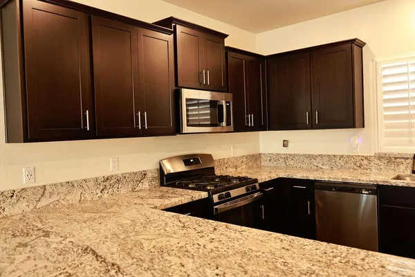 a kitchen with granite countertop a sink and a stove