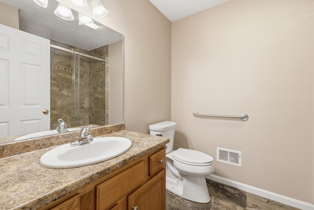 9 Rock Marsh Road, Unit B Wareham, MA 02571 - Photo 25 of 41 a bathroom with a granite countertop sink a toilet and a mirror