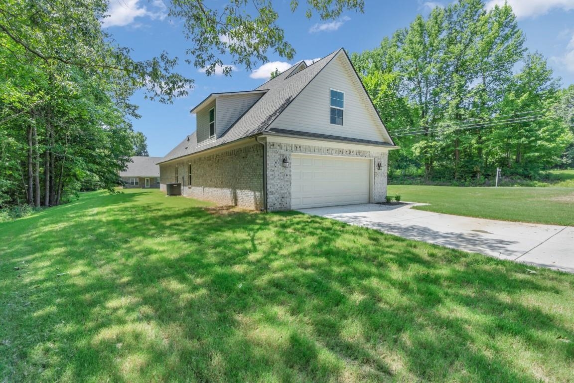 101 Walnut Ridge Ripley, TN 38063 - Photo 2 of 24 a view of a house with a yard and garage
