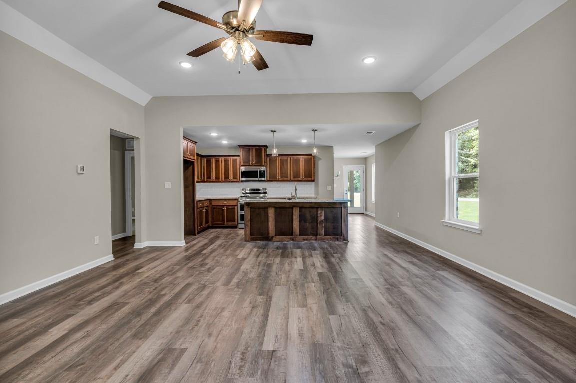 101 Walnut Ridge Ripley, TN 38063 - Photo 21 of 24 a big room with wooden floor windows and a kitchen view