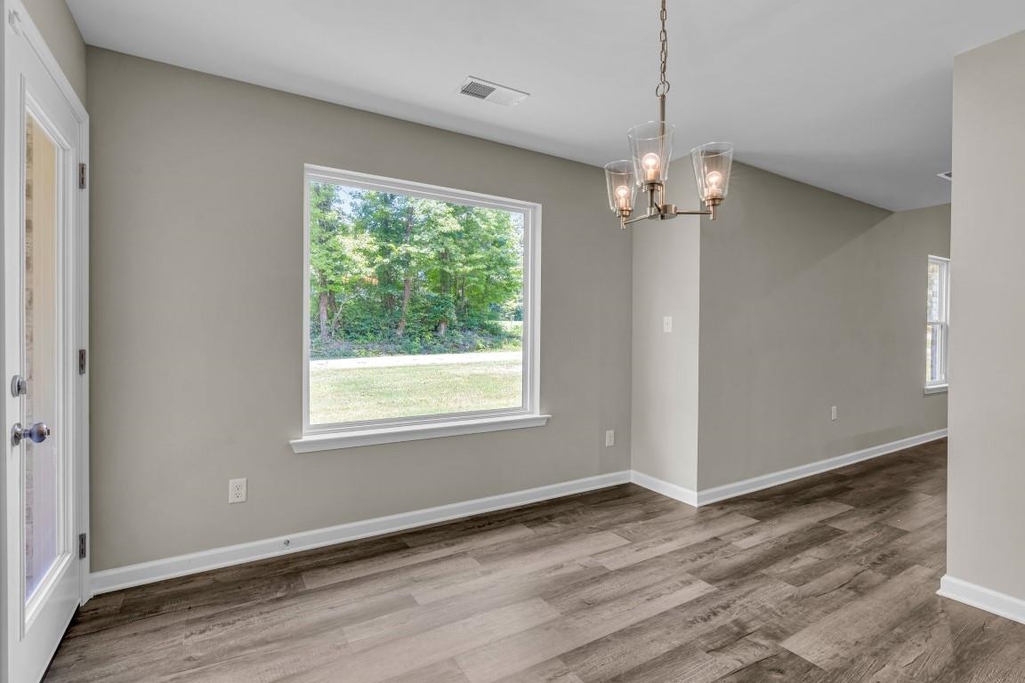 101 Walnut Ridge Ripley, TN 38063 - Photo 10 of 24 an empty room with wooden floor chandelier and windows