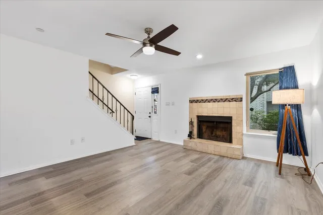 a view of a livingroom with wooden floor a fireplace and entryway