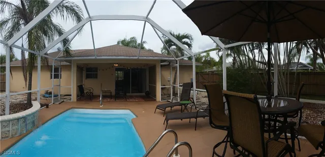 a view of a patio with table and chairs under an umbrella