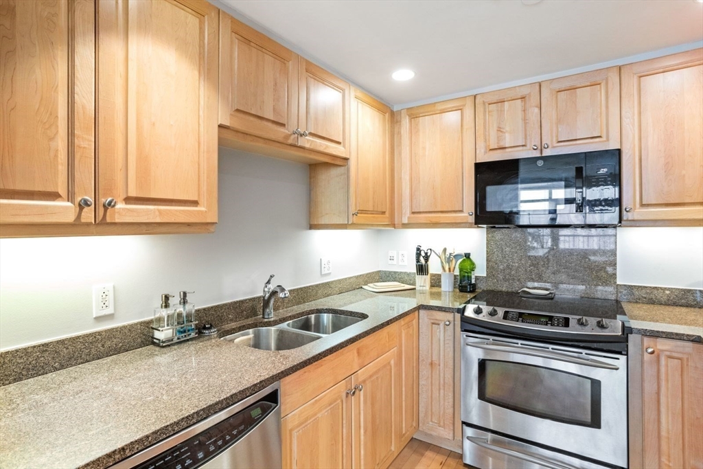 10 Bowdoin Street, Unit 514 Boston, MA 02114 - Photo 5 of 11 a kitchen with stainless steel appliances granite countertop a sink a stove and cabinets