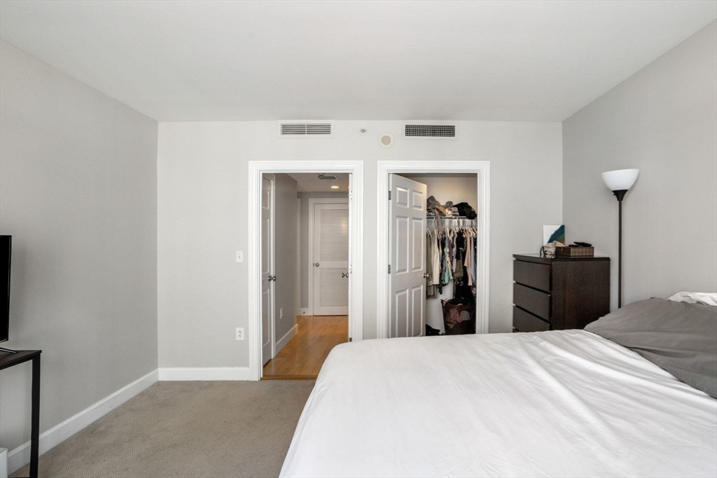 10 Bowdoin Street, Unit 514 Boston, MA 02114 - Photo 8 of 11 a bedroom with a bed and a mirror