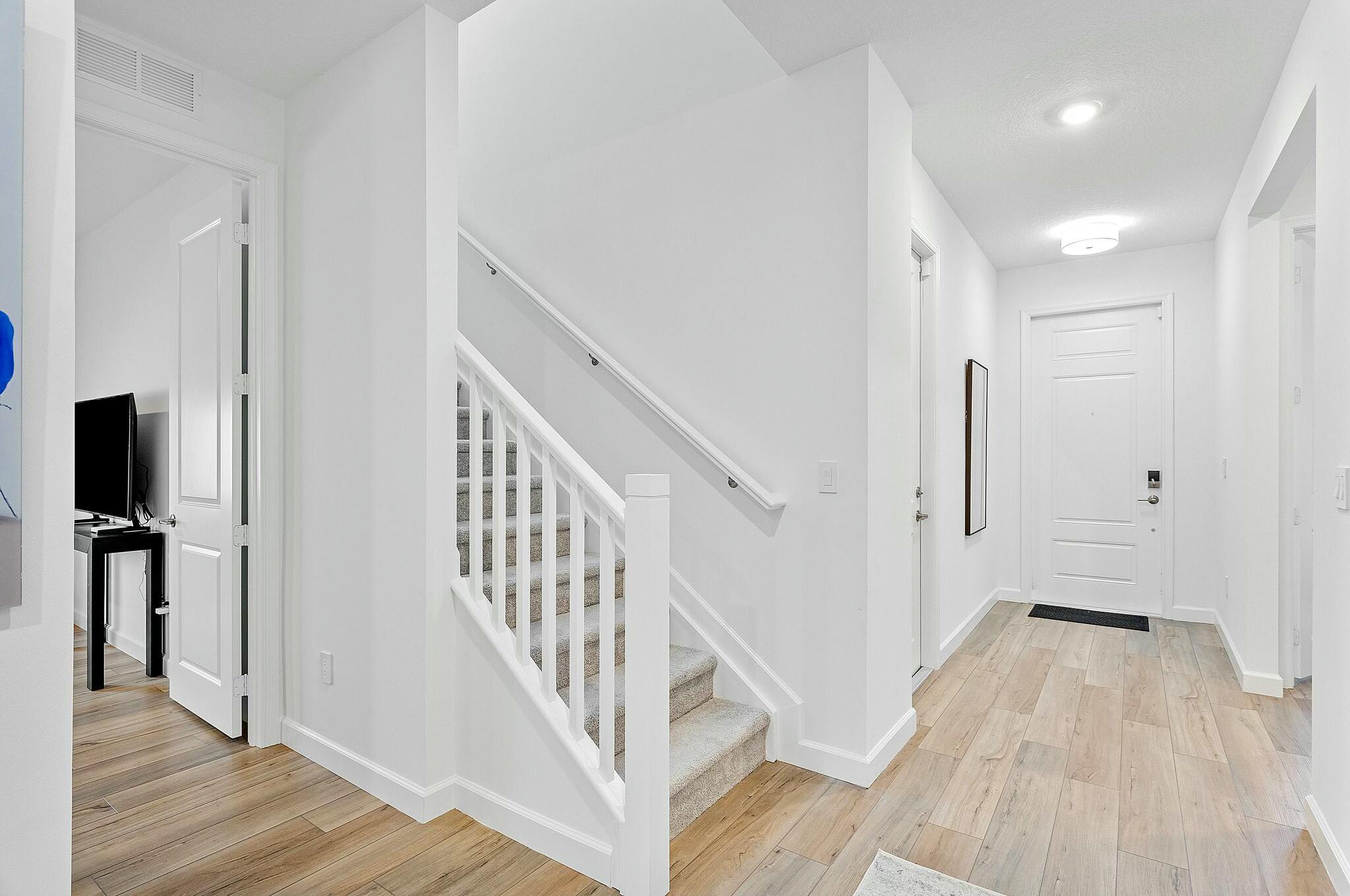 13404 Brotherhood Way Delray Beach, FL 33484 - Photo 23 of 44 a view of a hallway with wooden floor and staircase