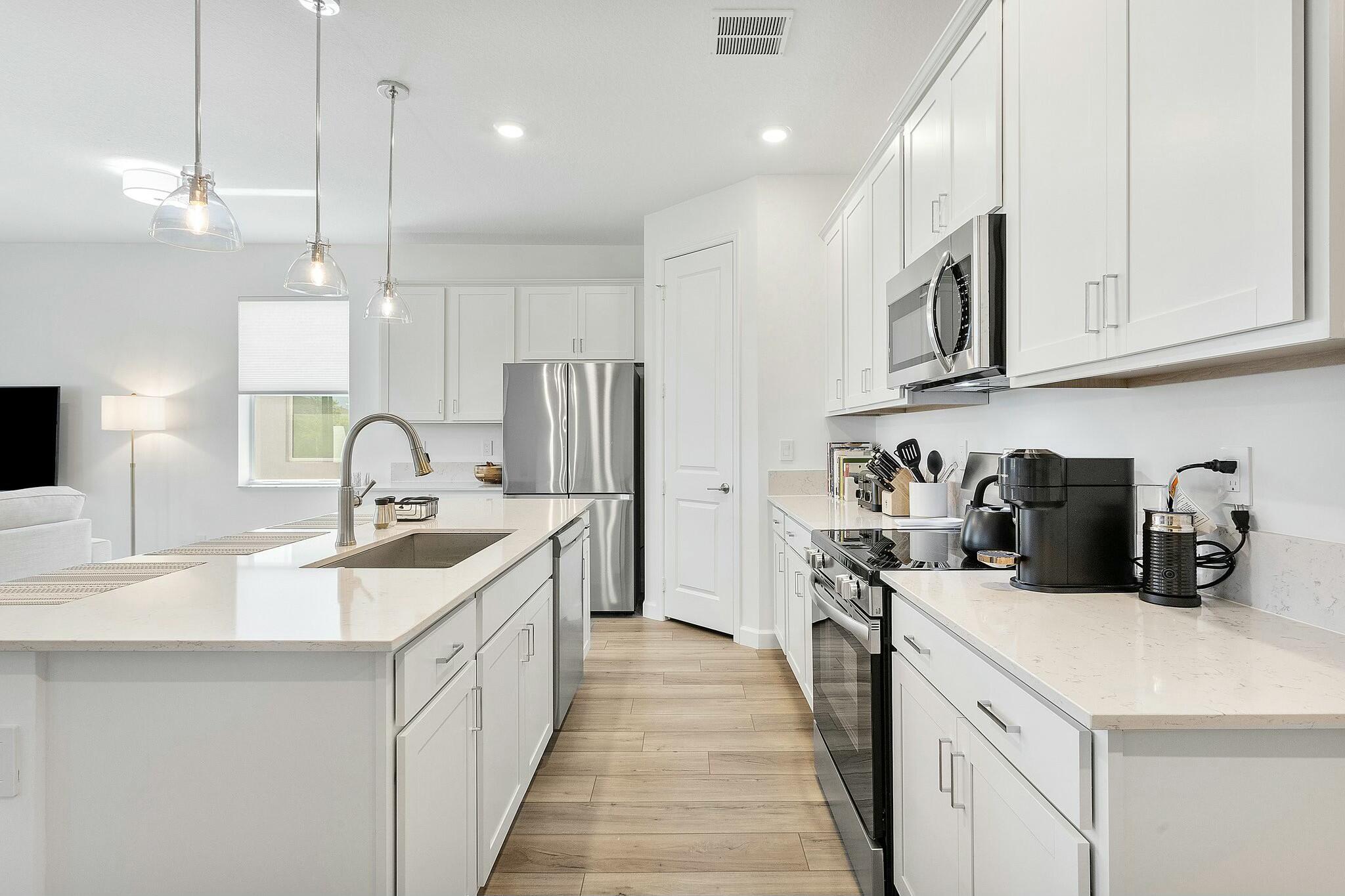 13404 Brotherhood Way Delray Beach, FL 33484 - Photo 6 of 44 a kitchen with stainless steel appliances granite countertop a sink a stove and a refrigerator