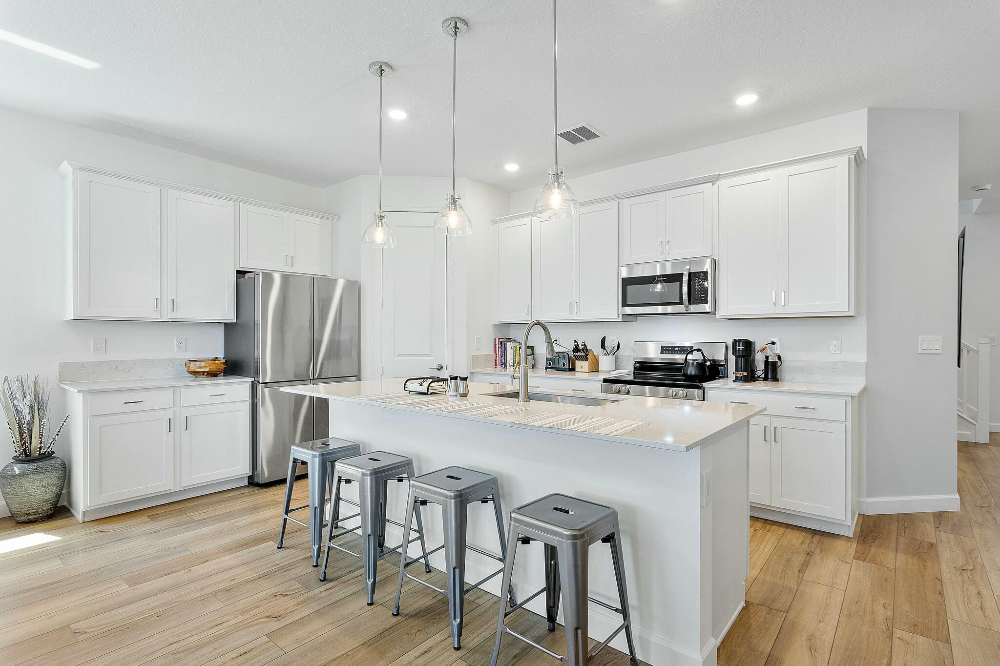 13404 Brotherhood Way Delray Beach, FL 33484 - Photo 7 of 44 a kitchen with white cabinets and stainless steel appliances