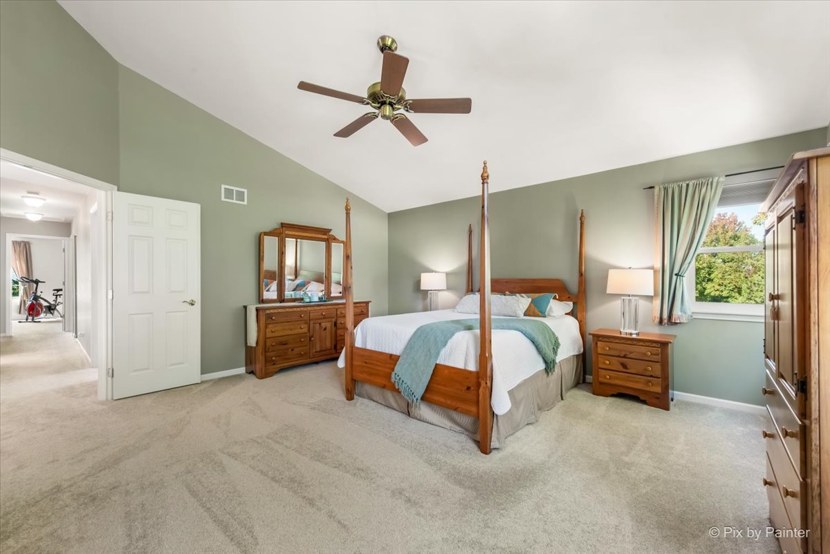 210 Ellis Road Lake In The Hills, IL 60156 - Photo 21 of 57 a spacious bedroom with a bed and a chandelier