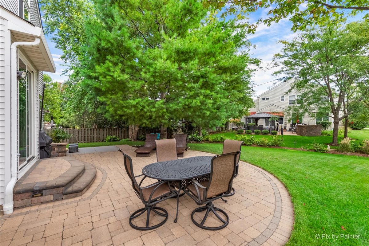 210 Ellis Road Lake In The Hills, IL 60156 - Photo 43 of 57 a view of a patio with table and chairs and potted plants with large tree