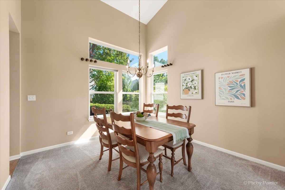 210 Ellis Road Lake In The Hills, IL 60156 - Photo 8 of 57 a dining room with furniture a large window and a chandelier