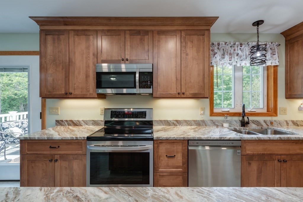 8 Ames Road Brookline, NH 03033 - Photo 4 of 26 a kitchen with granite countertop a stove a sink and a microwave