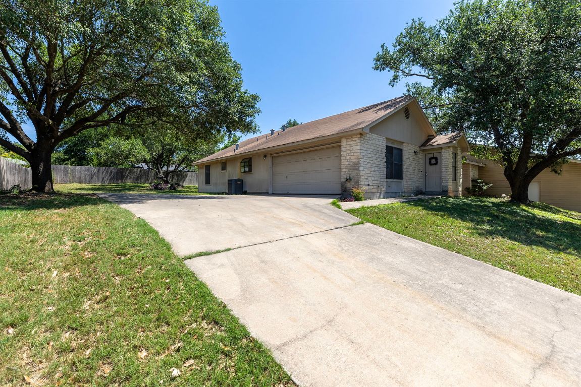 a front view of a house with a yard and trees