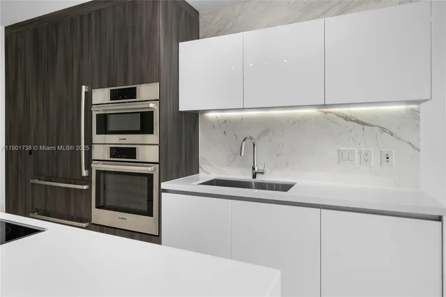 a kitchen with a sink and stainless steel appliances