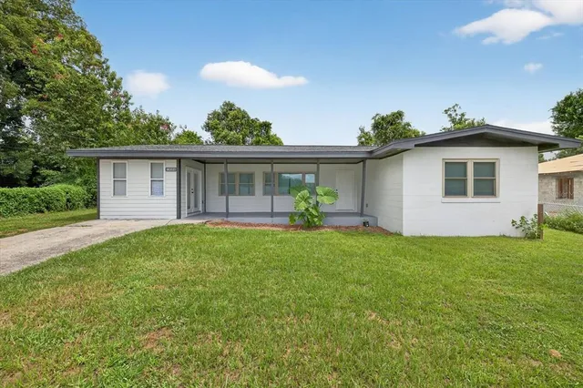a view of a house with backyard and sitting area