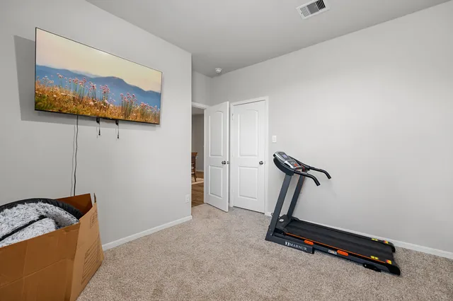 a room with gym equipment and a view of a couch