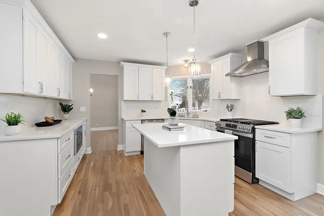 a large kitchen with cabinets wooden floor stainless steel appliances and cabinets