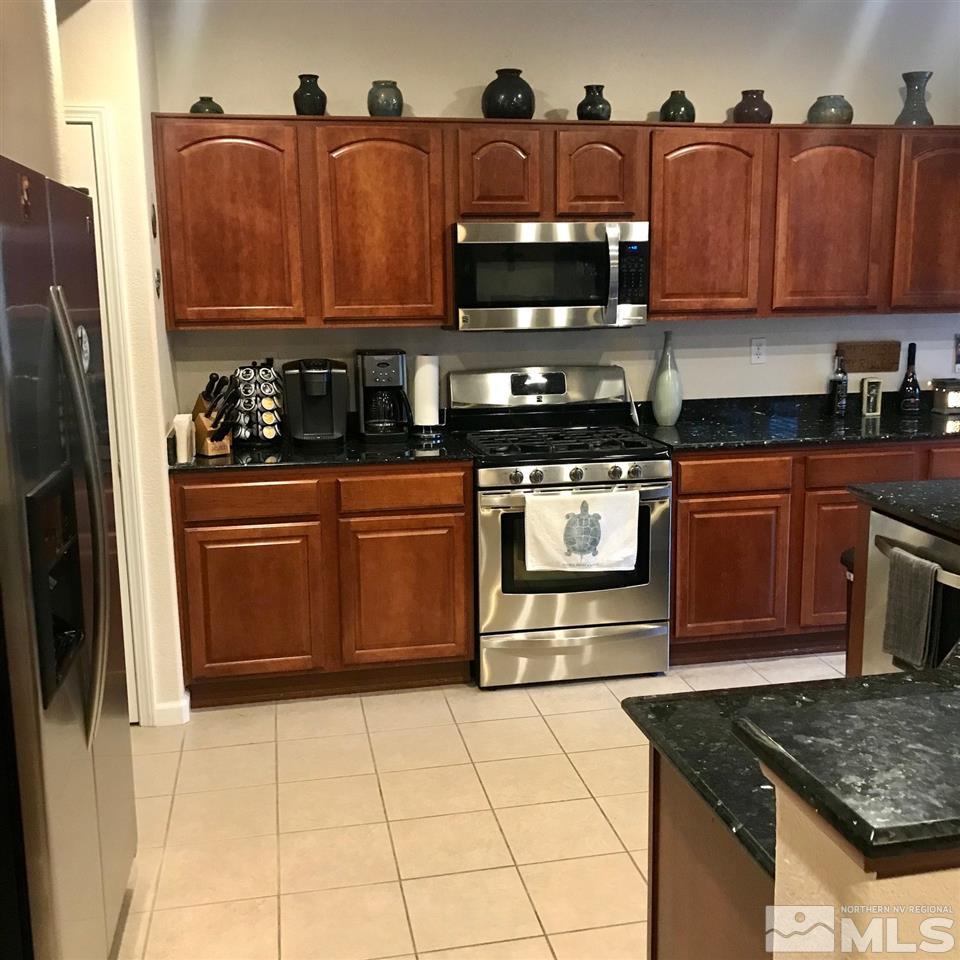 585 Connemaras Court Reno, NV 89521 - Photo 4 of 25 a kitchen with stainless steel appliances granite countertop a refrigerator and a stove