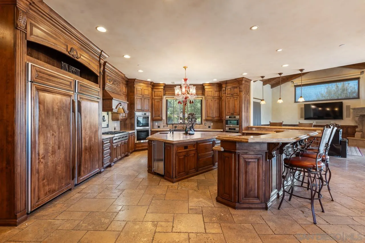 19612 Rangeland Road Ramona, CA 92065 - Photo 27 of 65 a kitchen with stainless steel appliances granite countertop wooden cabinets a sink and a refrigerator